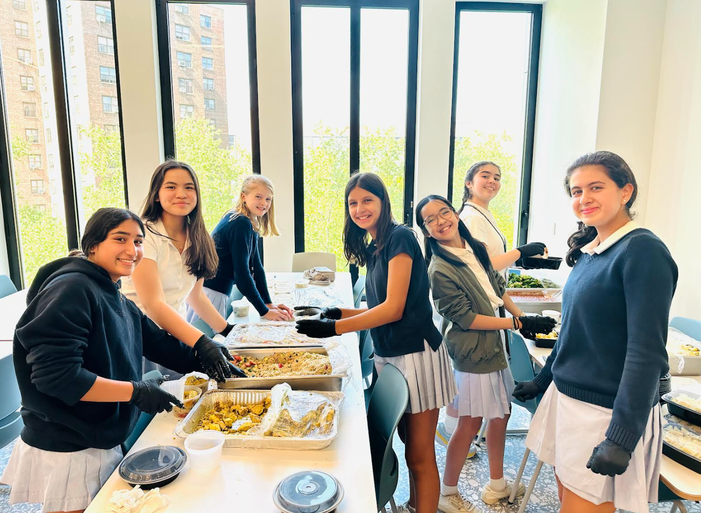 four students at community event table