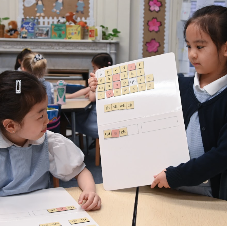 two lower school students holding handmade books