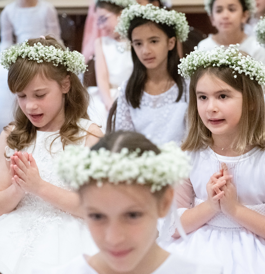 lower school students wearing floral crowns and white dresses